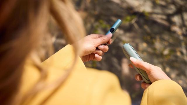 Una mujer con un dispositivo Iqos Iluma i