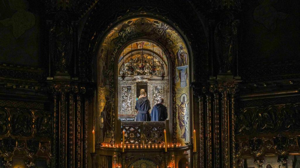 Dos religiosos desentronizan la Moreneta de su ubicación habitual, presidiendo la Basílica de Montserrat