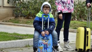Un niño refugiado junto a su maleta, en Barcelona
