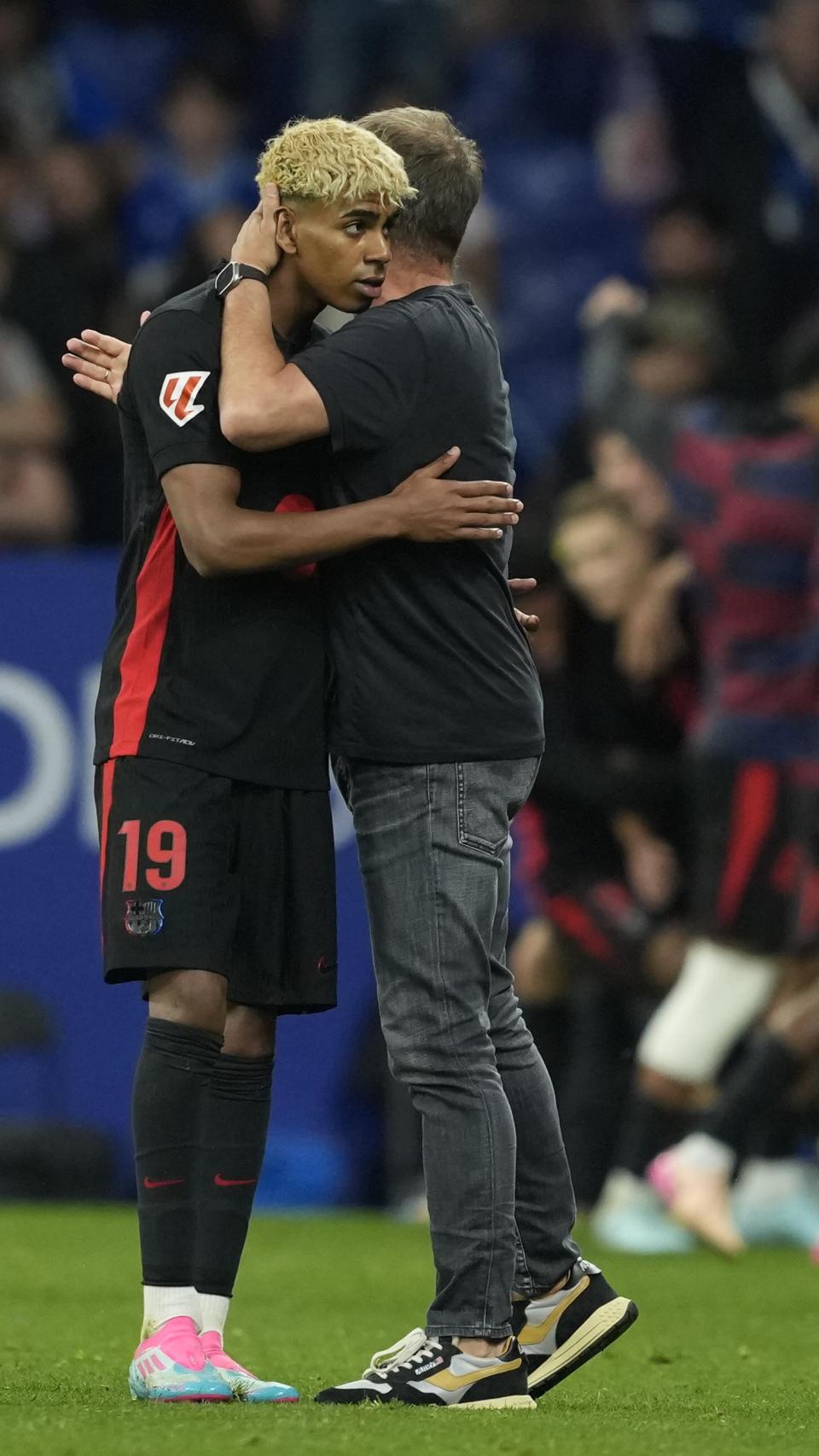 Lamine Yamal y Hansi Flick se abrazan tras ganar la Liga en el estadio del Espanyol