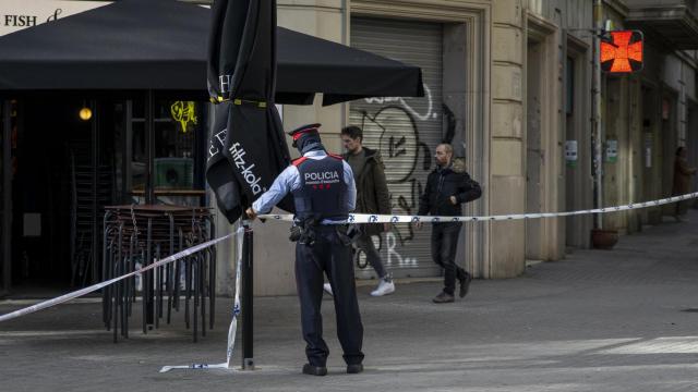 Un mosso acordona la zona donde se encontró el cadáver de Álex en un contenedor