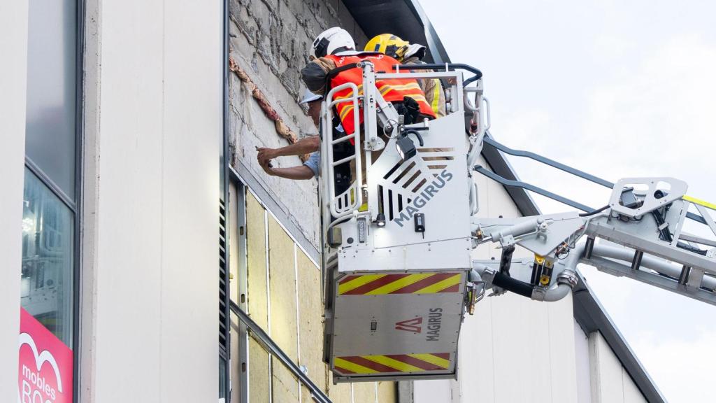 Los bomberos en la fachada de la nave