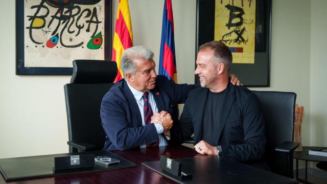 Joan Laporta y Hansi Flick estrechan la mano en el acto de renovación del técnico alemán con el Barça