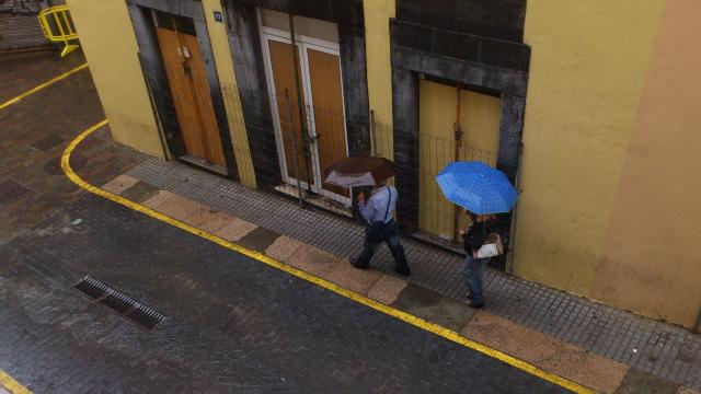 Dos personas pasean bajo la luvia