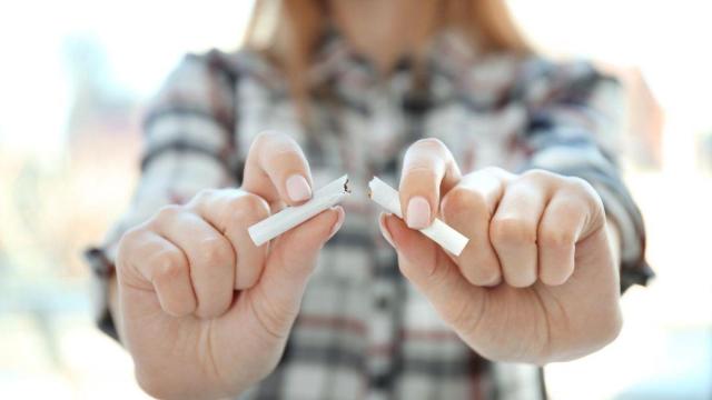Una persona rompe un cigarro de tabaco