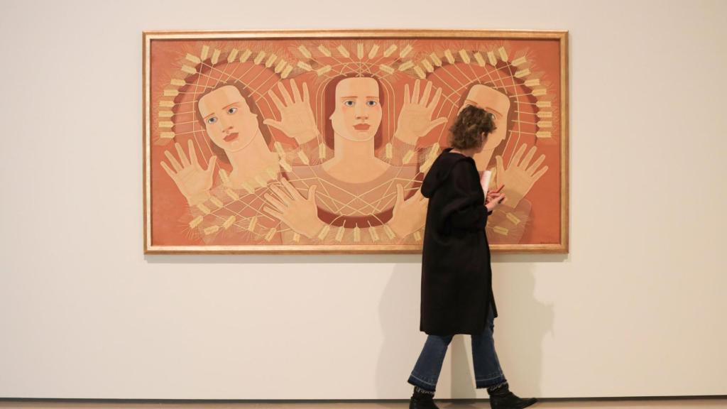Una mujer pasa por delante del lienzo de Maruja Mallo ‘Canto de las espigas’ (1939).