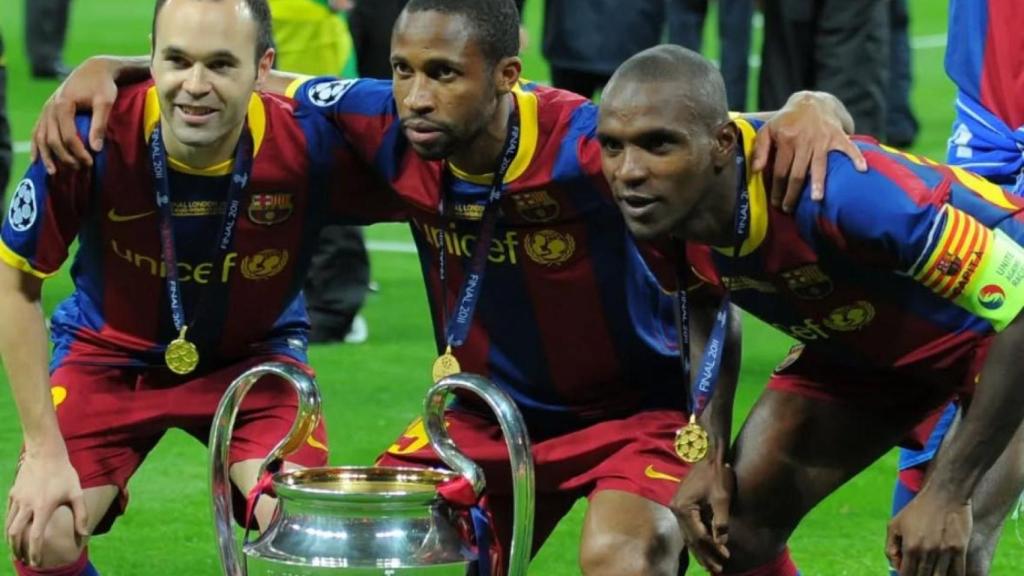 Andrés Iniesta, Seydou Keita y Eric Abidal posando junto al trofeo de la Champions League en 2011