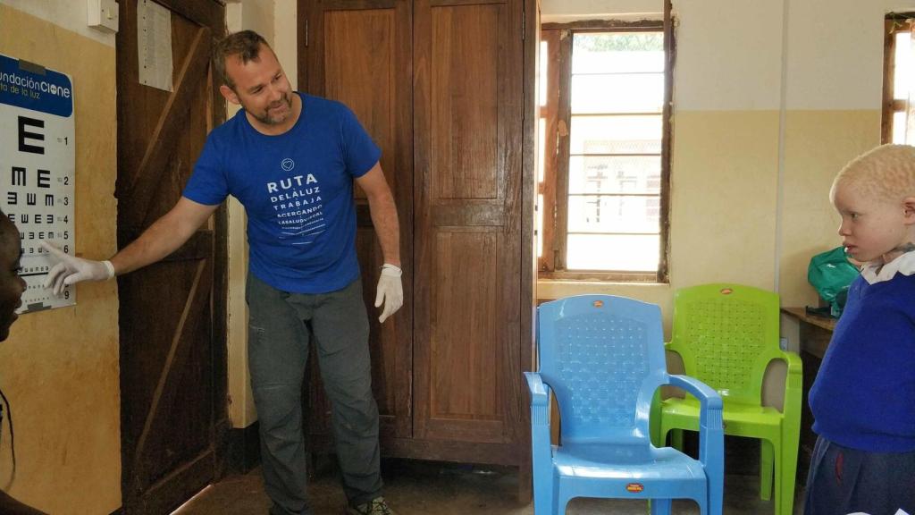 Un miembro de la Fundación Ruta de la Luz revisa la vista a un niño albino en un colegio