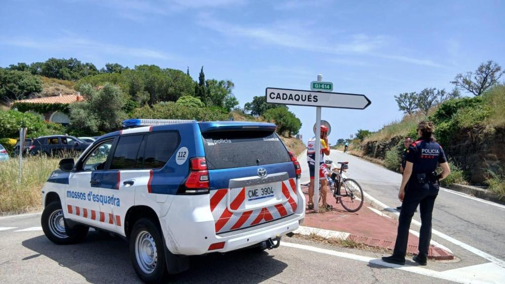 Una patrulla de los Mossos d'Esquadra corta el acceso a un ciclista en la carretera de Cadaqués por un incendio