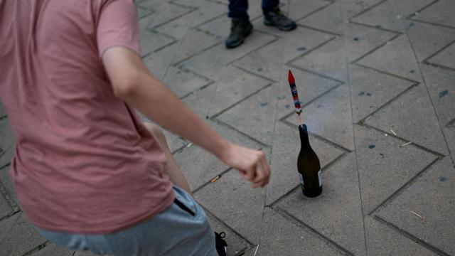 Una persona enciende petardos durante una verbena de San Juan