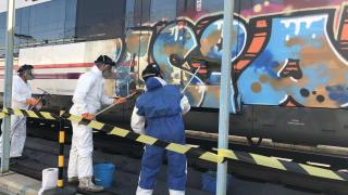 Varios trabajadores limpian grafitis de un tren