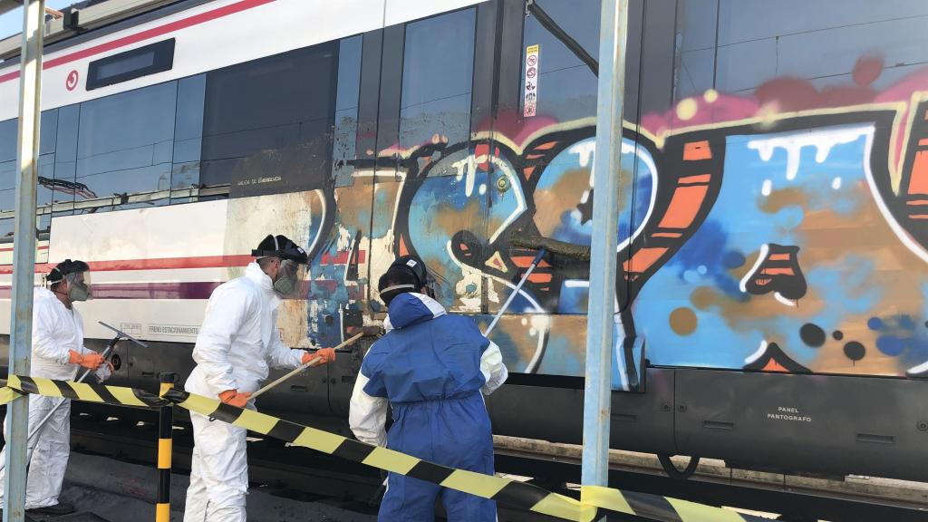 Varios trabajadores limpian grafitis de un tren
