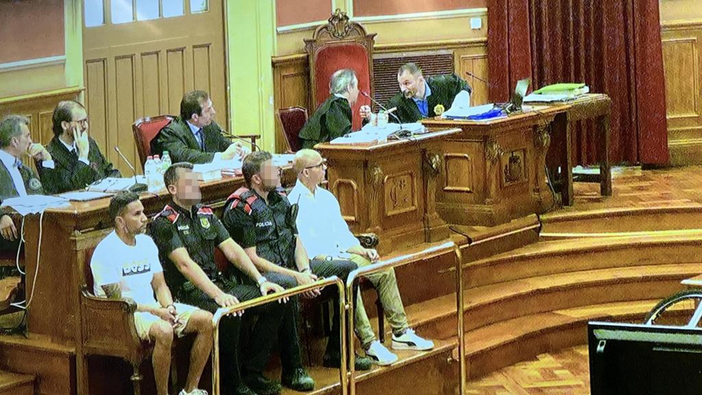 En el banquillo de los acusados: Daniel Díaz Mora (izquierda) y Sergio Gutiérrez Martín (derecha) entre dos agentes de los Mossos d'Esquadra