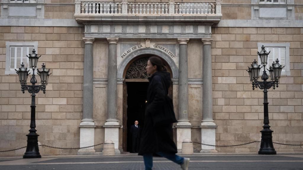 Una persona pasea por delante del Palau de la Generalitat