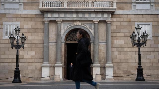 Una persona pasea por delante del Palau de la Generalitat