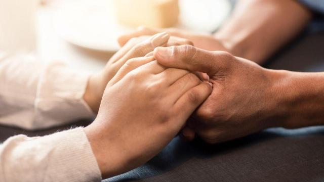 Plano de detalle de dos personas dándose la mano