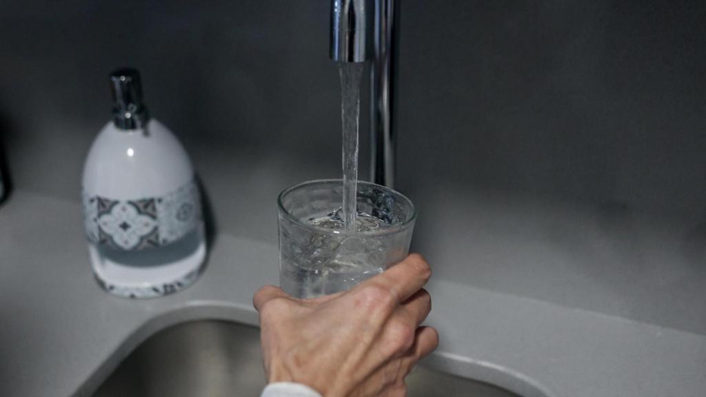 Una persona se sirve un vaso de agua