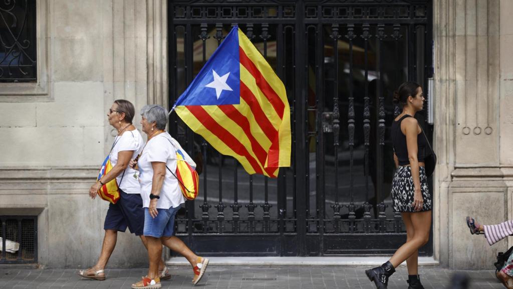 Dos mujeres portan una bandera estelada durante la Diada de 2024