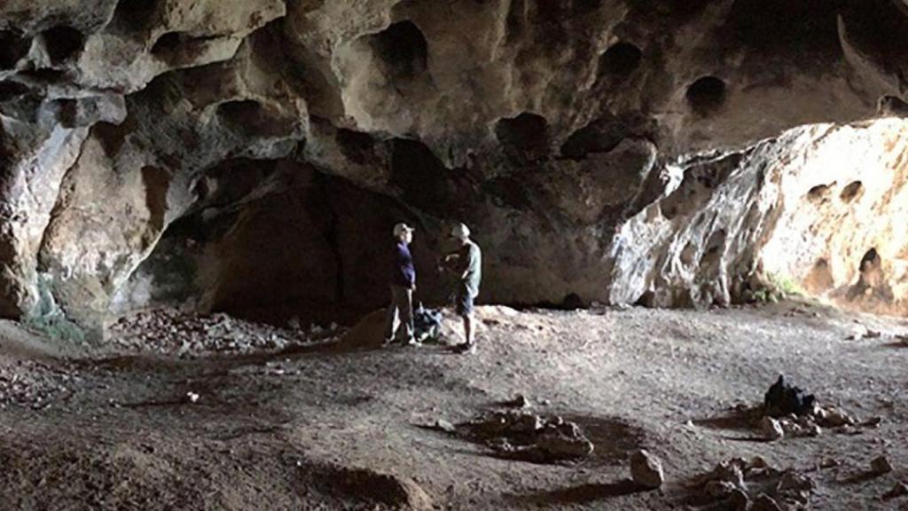 Dos personas en la entrada de la Cova del Tabac