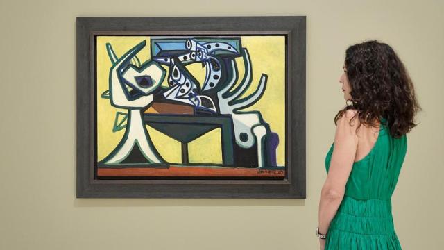 Una mujer observa el lienzo ‘Naturaleza muerta con revólver’ (1957), de Óscar Domínguez.