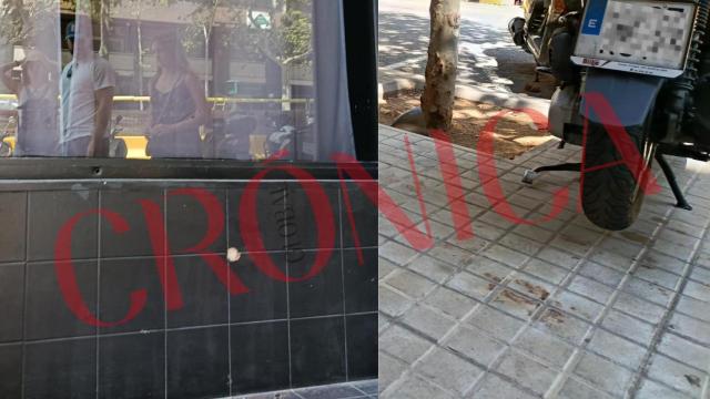 El impacto de dos disparos en el escaparate de un restaurante, y sangre de la víctima derramada en la calle