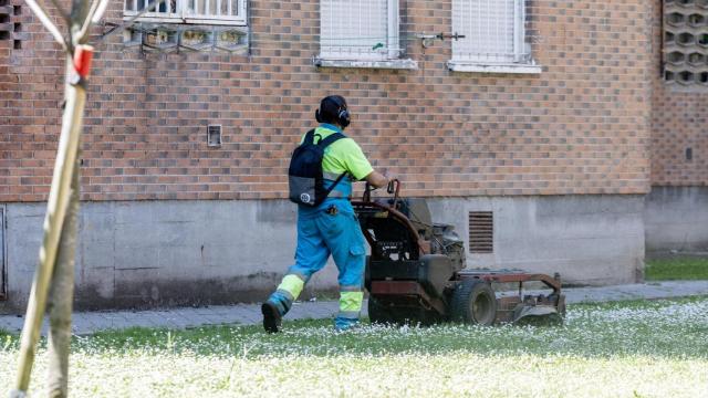 Un jardinero trabajando en un barrio residencial