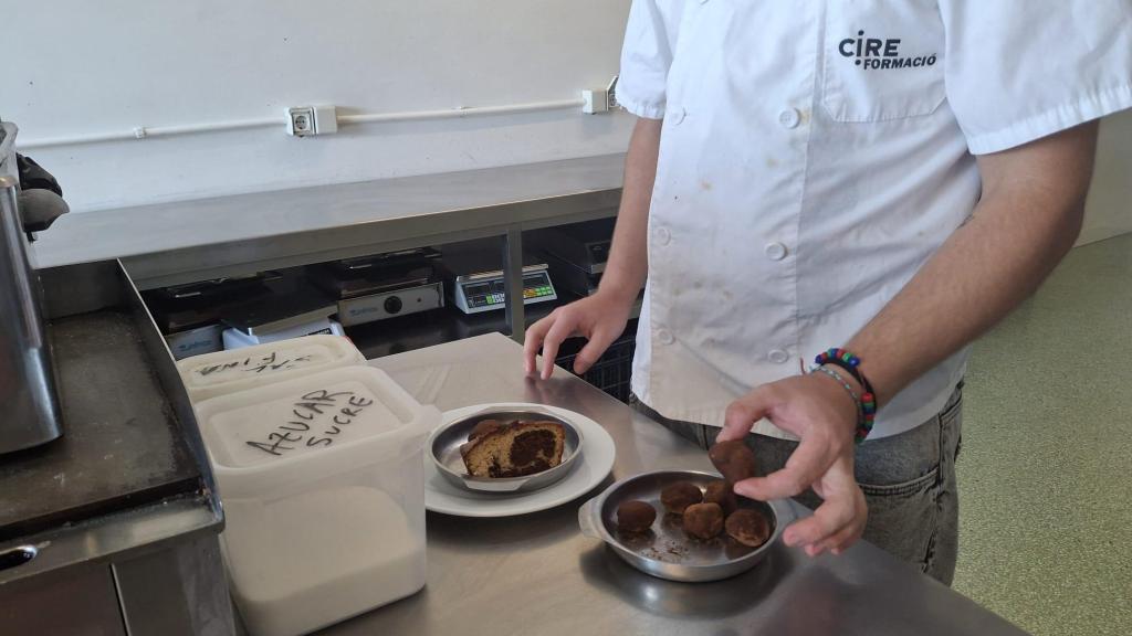 Un menor del Centro Educativo Can Llupià, en Barcelona, muestra los platos que preparan en los talleres de hostelería