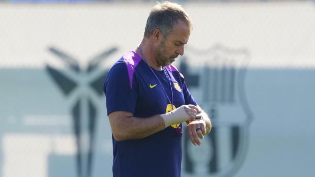 Hansi Flick mira su reloj en el entrenamiento del Barça