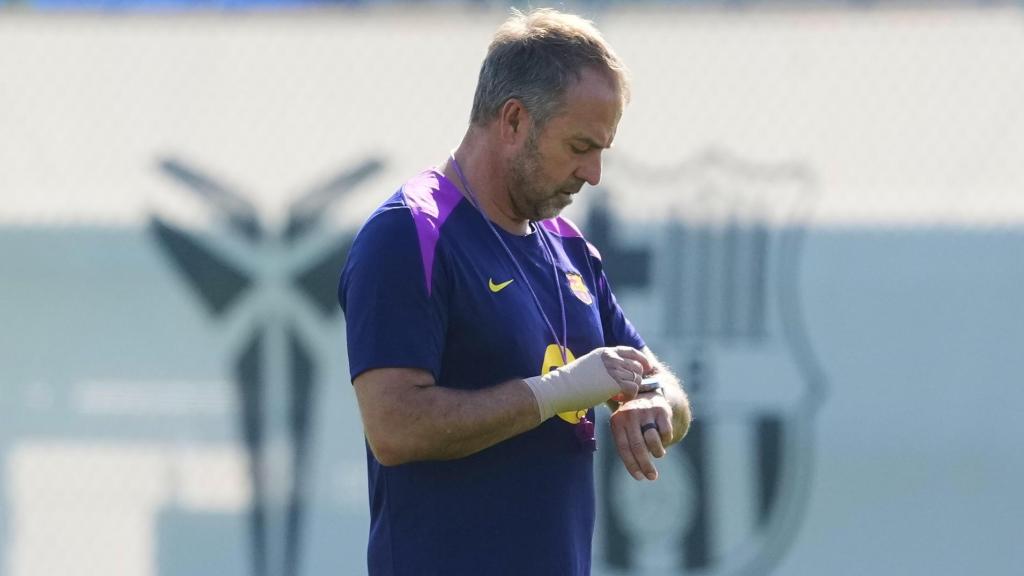 Hansi Flick mira su reloj en el entrenamiento del Barça