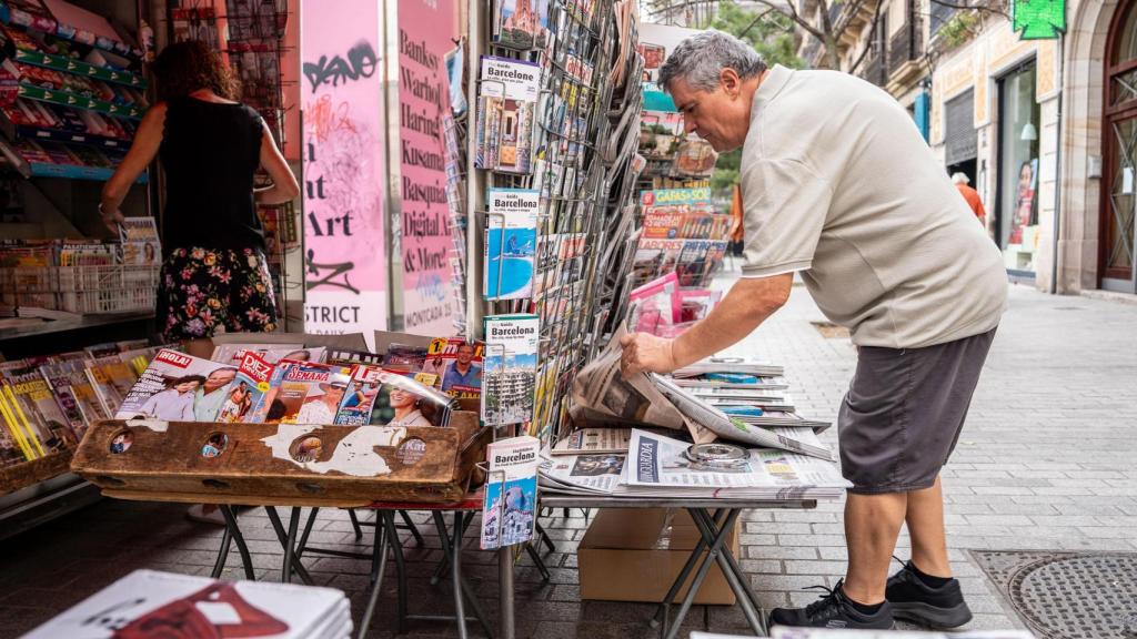 Juan Viso ordena los periódicos en el Quiosco del Born
