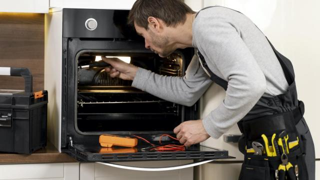 Un técnico trata de reparar un horno eléctrico