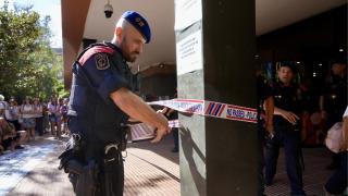 Un mosso d'esquadra precinta la entrada de la Conselleria de Educación ante los manifestantes por las mejoras de las condiciones del personal laboral del departamento