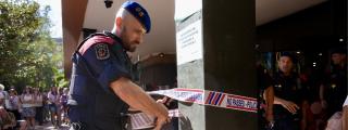 Un mosso d'esquadra precinta la entrada de la Conselleria de Educación ante los manifestantes por las mejoras de las condiciones del personal laboral del departamento