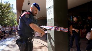 Un mosso d'esquadra precinta la entrada de la Conselleria de Educación ante los manifestantes por las mejoras de las condiciones del personal laboral del departamento