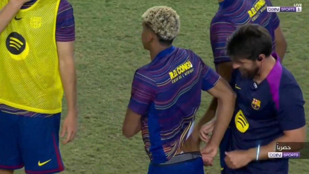 Un fisioterapeuta del Barça trata unas molestias de Lamine Yamal en la espalda, durante el calentamiento del partido contra el Rayo Vallecano