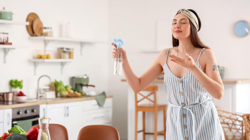 Mujer rociando ambientador en su casa