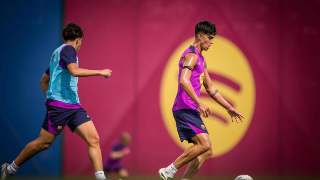 Marc Bernal conduce el balón en un entrenamiento del Barça, perseguido por Toni Fernández