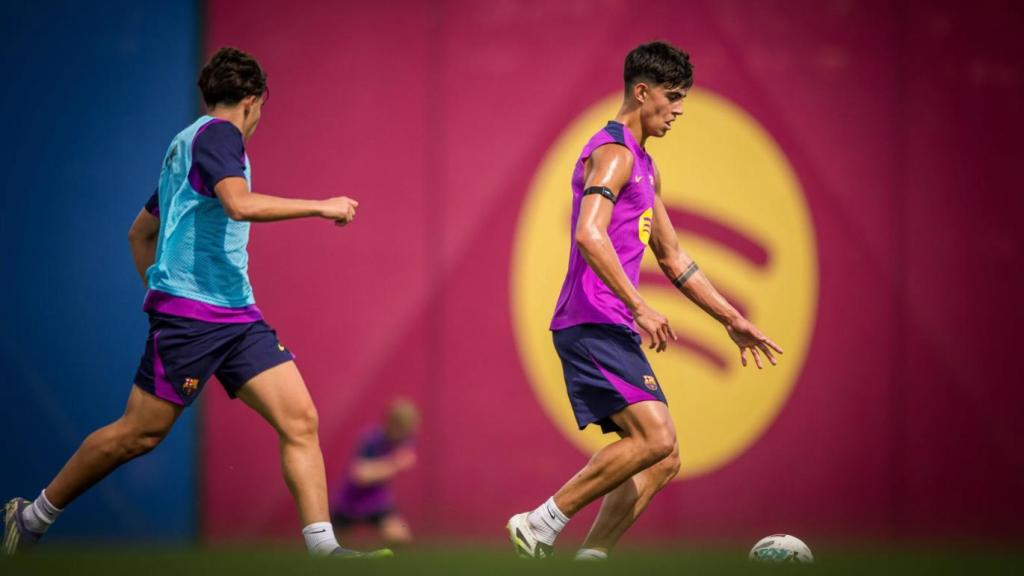 Marc Bernal conduce el balón en un entrenamiento del Barça, perseguido por Toni Fernández