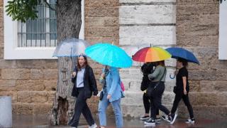 Transeuntes bajo sus paraguas durante la intensa lluvia. A 11 de octubre de 2024, en Cádiz (Andalucía, España).