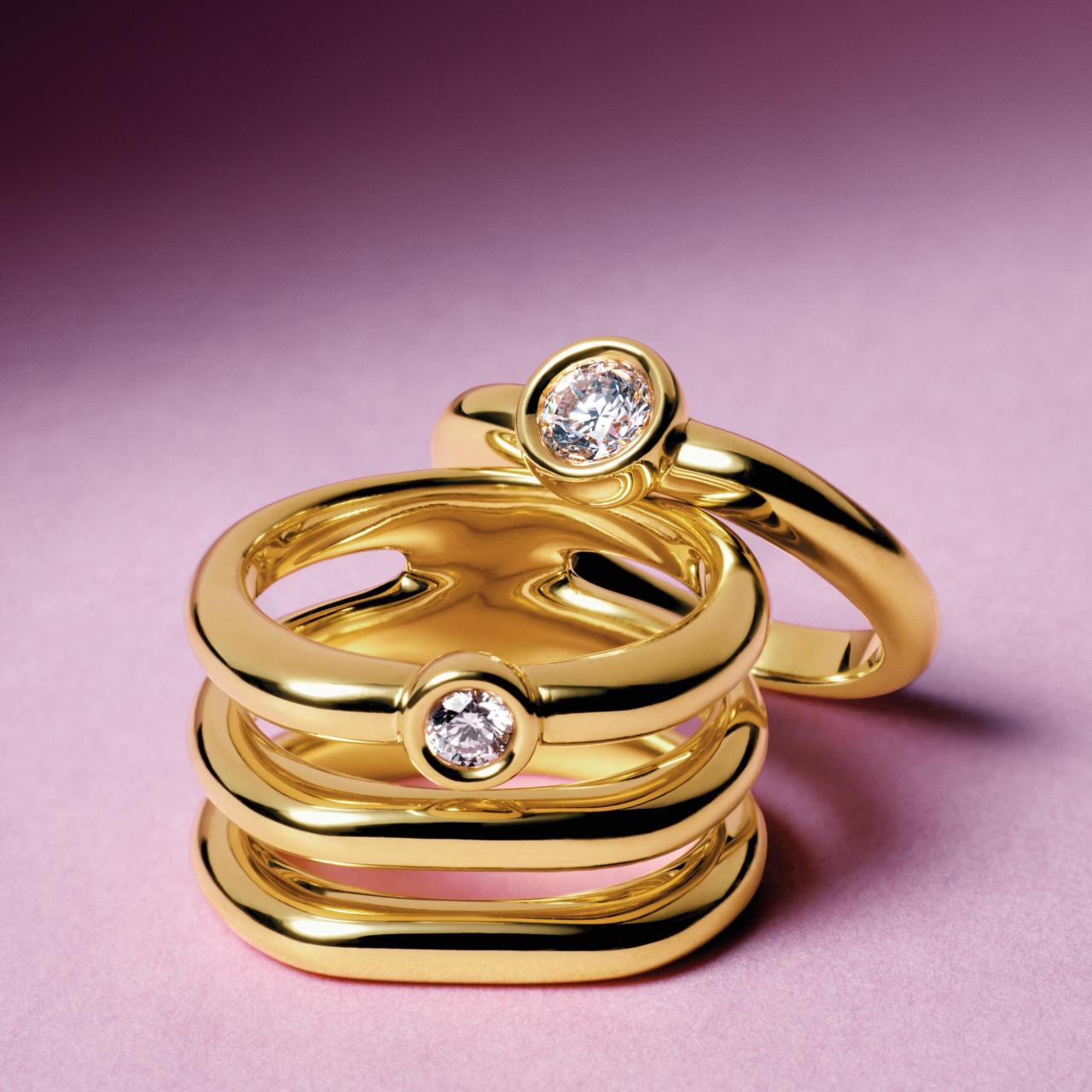 Anillos de oro con diamantes apilados, creando un diseño moderno y atrevido que no pasa desapercibido