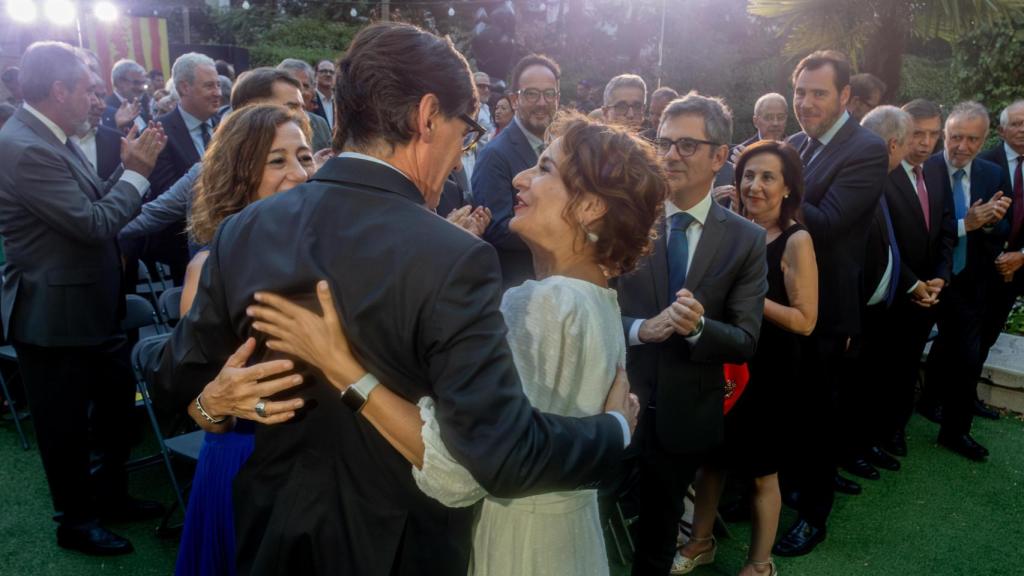 El presidente de la Generalitat, Salvador Illa, abraza a la vicepresidenta primera y ministra de Hacienda, María Jesús Montero, en la celebración de la Diada Nacional de Cataluña, en Madrid