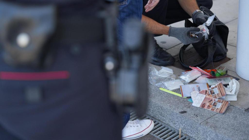 Agente de los Mossos revisando la mochila de uno de los identificados