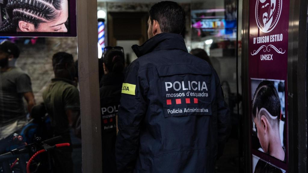 Agente de la Policía Administrativa de los Mossos d'Esquadra entrando en la peluquería sospechosa de comprar objetos robados