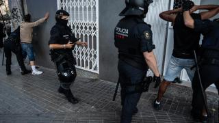 Agentes de la Brimo de los Mossos d'Esquadra cacheando a dos personas que se han identificado