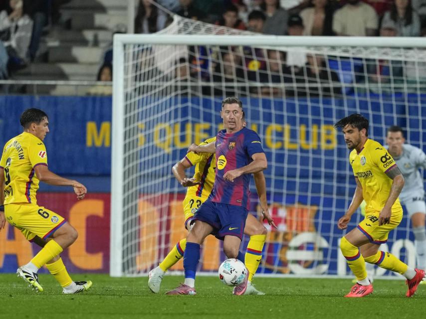 Robert Lewandowski controla el balón, rodeado defensores durante el Barça-Getafe