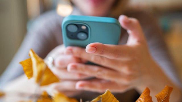 Una mujer mira su teléfono móvil