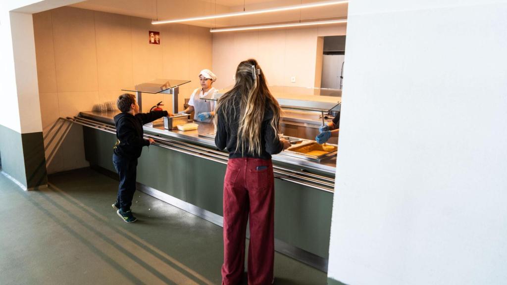 Un niño y una profesora se sirven la comida en el comedor del Montiba