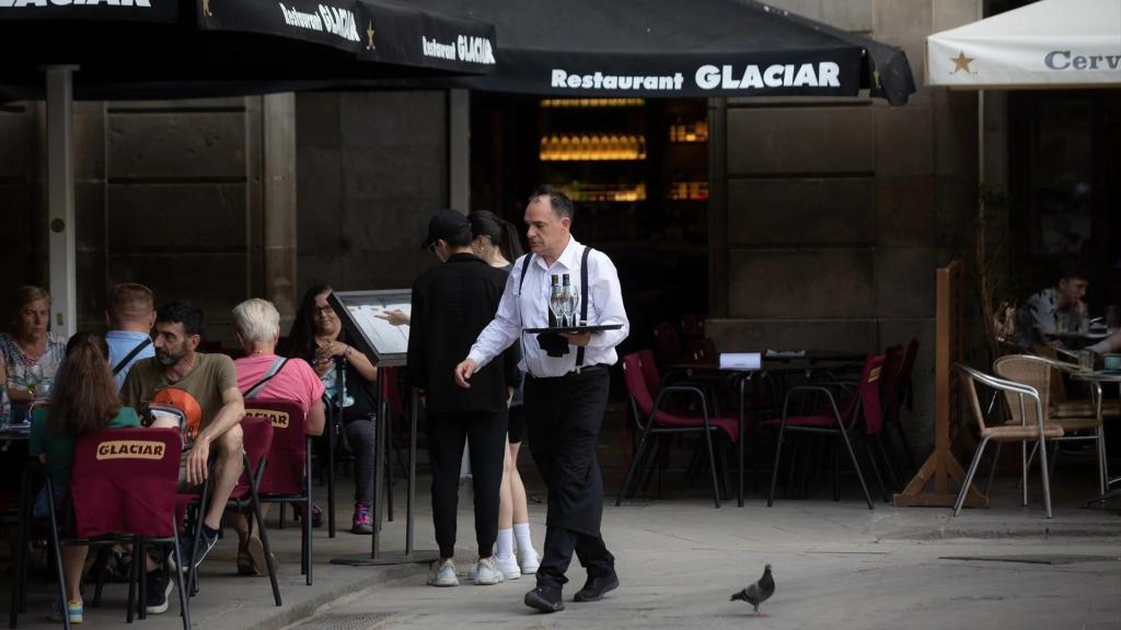 Un camarero atiende a sus clientes en una terraza