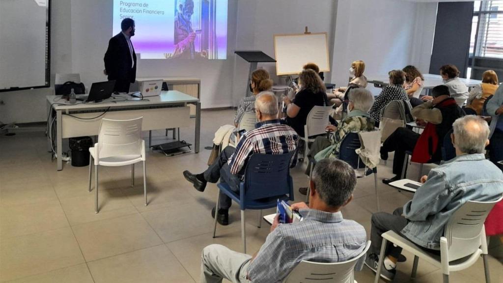 Personas mayores asisten a una charla sobre educación financiera
