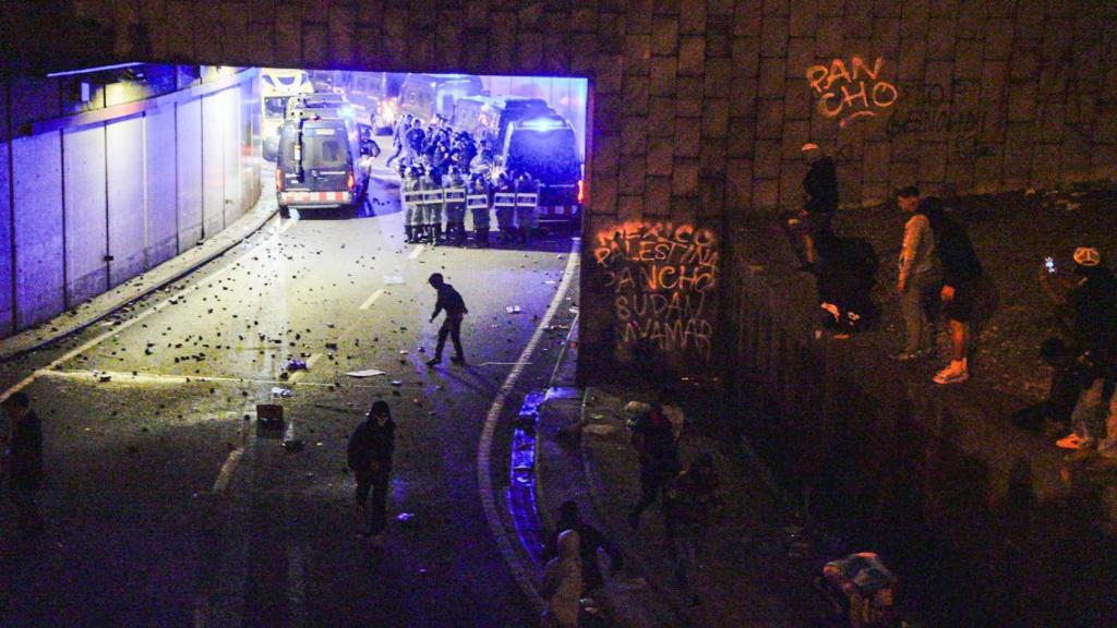 Un grupo de manifestantes lanza piedras y objetos a un cordón policial en la plaza de Drassanes de Barcelona